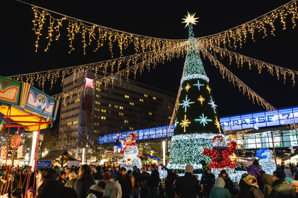 Festlich geschmückter Weihnachtsbaum mit Lichterketten und Weihnachtsfiguren.